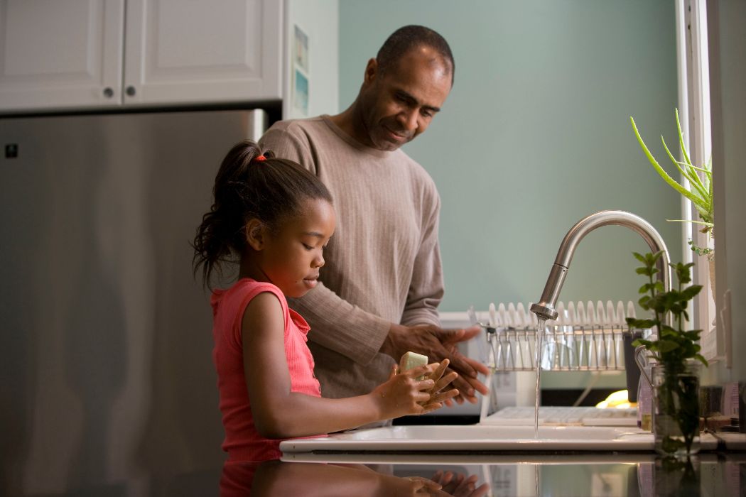 Picture of a man teaching his daughter to wash her hands - first priority insurance