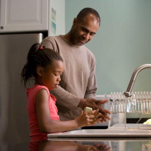 Picture of a man teaching his daughter to wash her hands - first priority insurance